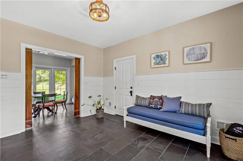 Welcoming entry hall with oversized closet on slate flooring.