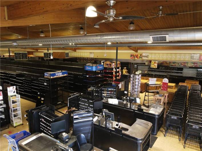 Interior from entrance with grocery check-out lines, shopping carts and display cases