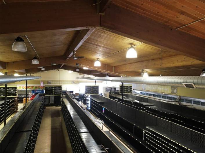 Aerial view from front of store with shelving, aisle signs, freezer cases and more