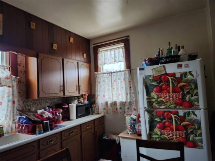 The eat-in kitchen has a wall of cupboards.