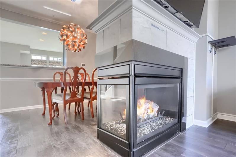 The dual sided fireplace has a tile detailing and adds warmth to the home that permeates throughout.