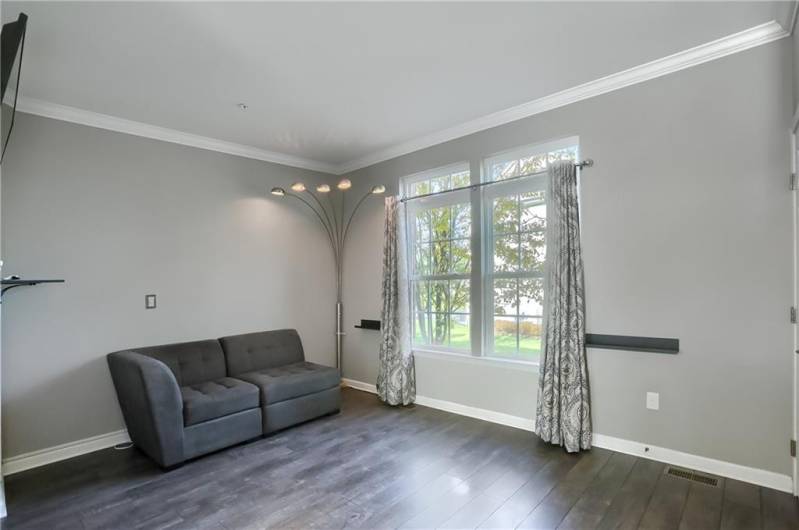 Enjoy family and friends in the family room boasting a vivid window, crown molding, neutral tone and access to the powder room.