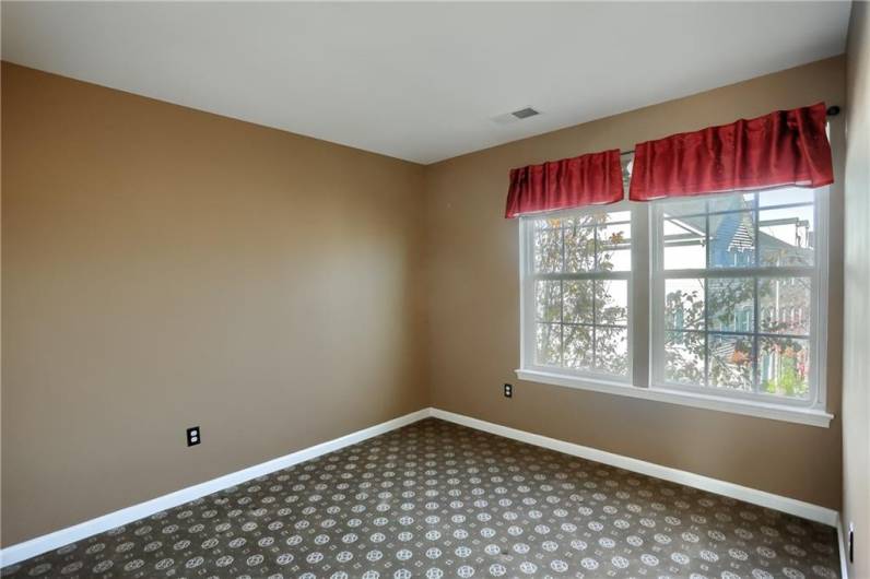 Guest bedroom with a neutral tone and bright window.