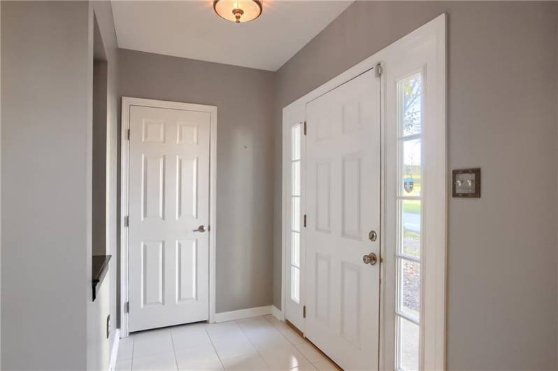 Plenty of natural light floods the entry way, and glistens on the tile flooring.