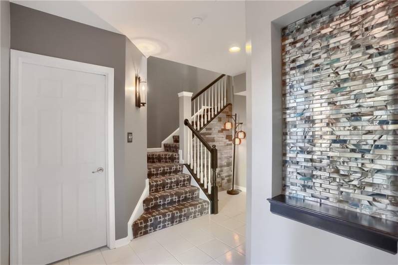 A custom tile detailed nook is the perfect place to display a welcome sign or family heirloom. High end carpeting carries you to the main level living area.