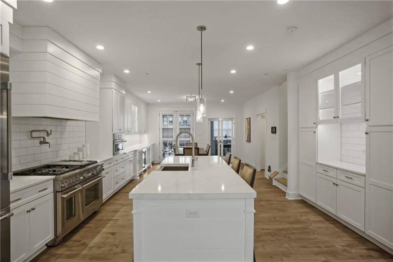 Endless white counters, custom subway tile and stylish white custom cabinetry create a sleek modern slate for your pop of color.