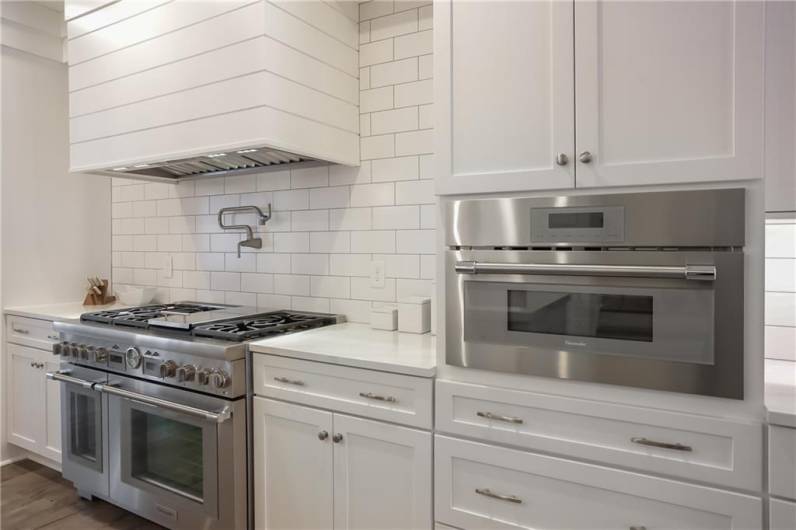 Modern white cabinetry complements the stainless steel appliances.