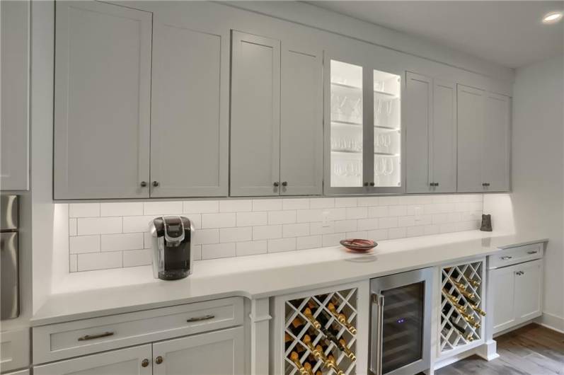 The kitchen has a buffet area with built in wine racks, a beverage cooler, showcase cabinets and beautiful finishes.