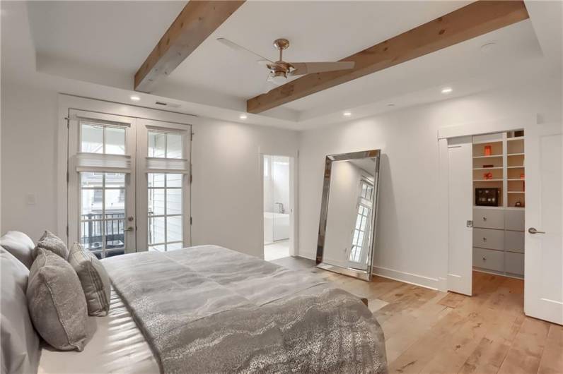 A pocket door leads to the walk in closet with closet system.