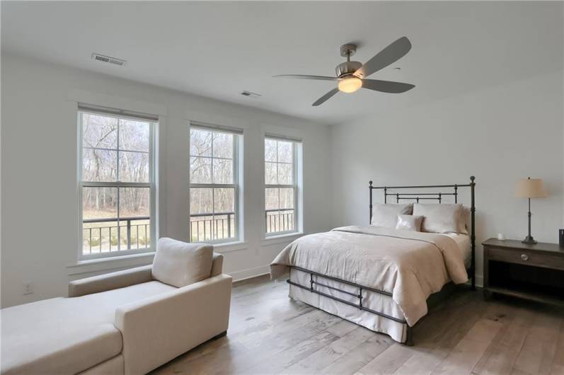 A wall of windows floods this guest bedroom with natural lighting.