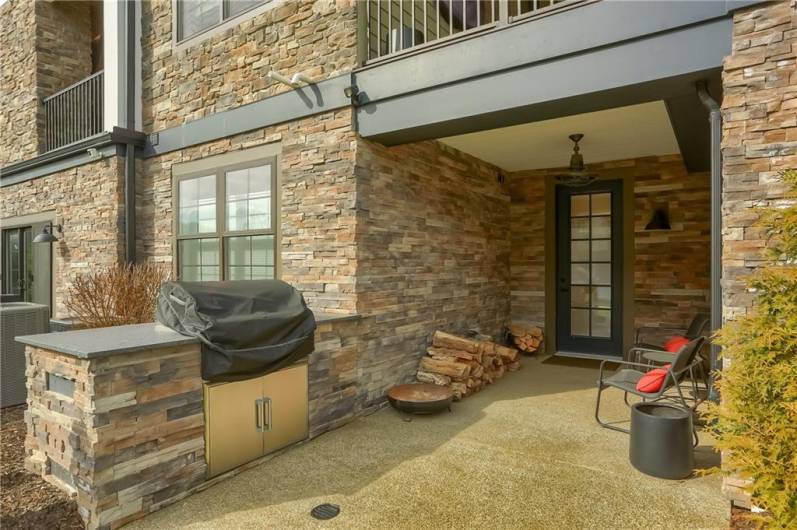 The stone accenting extends to include a outdoor kitchen area with a built in gas grill.