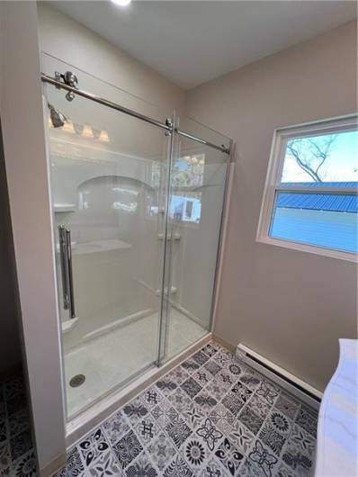 Great shower will beautiful glass sliding doors.