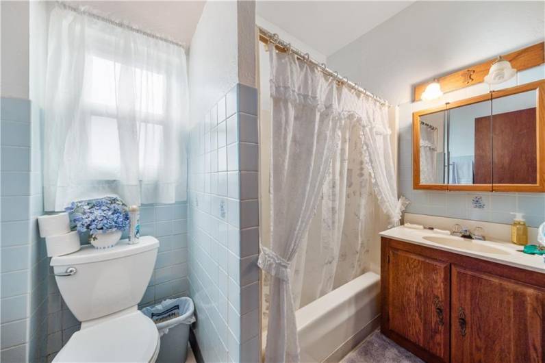 Updated full bath with oak vanity.