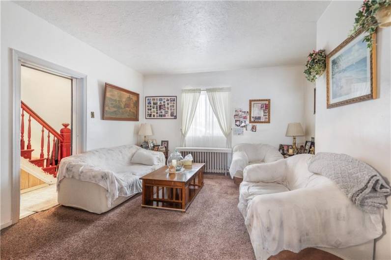 The spacious living room is freshly painted with updated carpet.