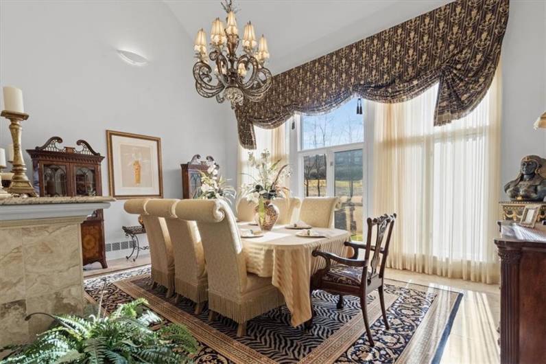 A wall of two-story windows with panoramic views of the back yard and golf course