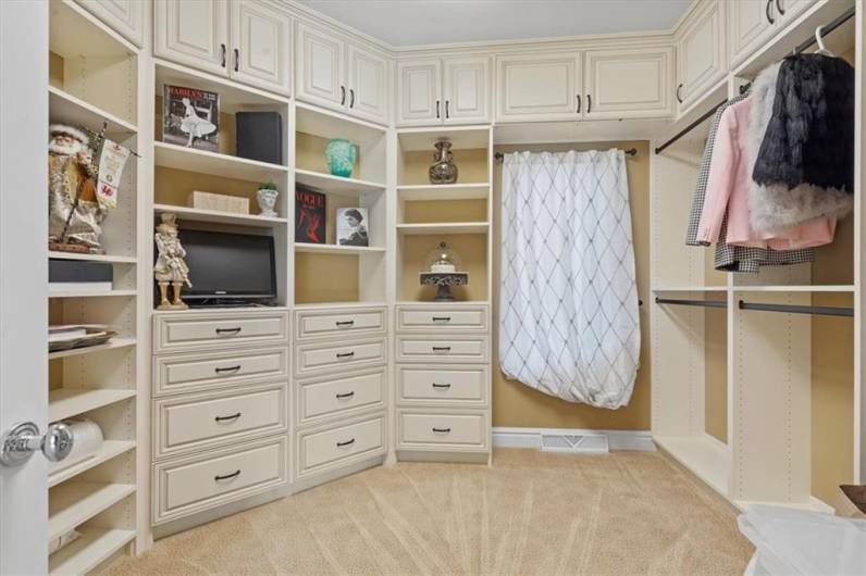 Spacious closet with custom built-in cabinetry and drawers