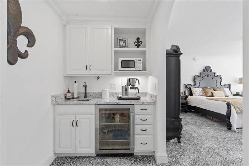 Convenient coffee bar with custom cabinetry, sink, granite countertop and Sub-Zero mini fridge