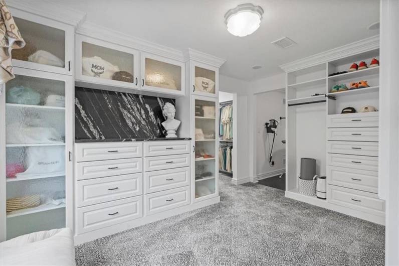 Extravagant dressing room with custom designed built-in drawers & cabinetry, expansive walk-in closet with custom built-ins & cedar lined closet areas.