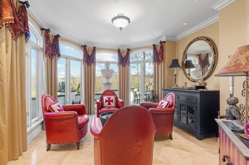 Floor to ceiling octagonal windows and Travertine floors, currently being utilized as a sitting room