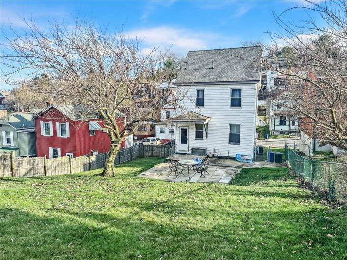 Rear Living space includes small rear porch, large patio, and huge beautiful, fully enclosed greensapce backyard w/firepit and cherry blossom tree!