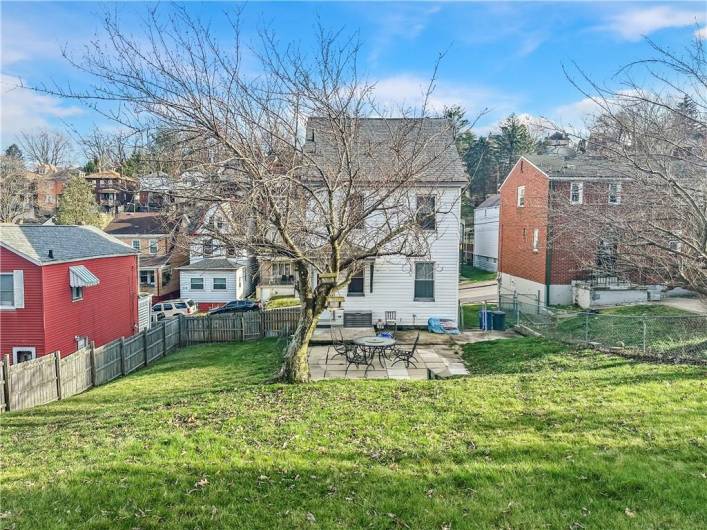 Rear Living space includes small rear porch, large patio, and huge beautiful, fully enclosed greensapce backyard w/firepit and cherry blossom tree!