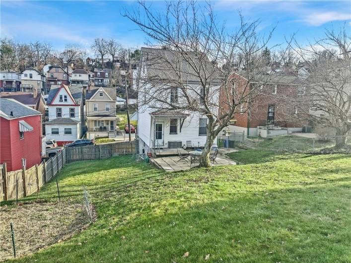 Rear Living space includes small rear porch, large patio, and huge beautiful, fully enclosed greensapce backyard w/firepit and cherry blossom tree!