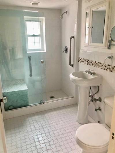 Primary bathroom with walk-in shower and bench