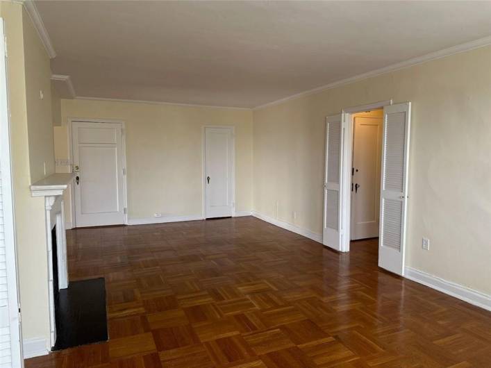 Alt view of living room/sitting area with front door and coat closet shown