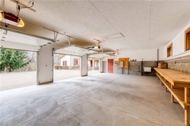 Oversized garage with 3 separate garage doors and a workbench that is included.