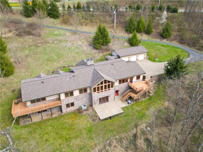 Rear elevation shows large primary suite deck and deck from the kitchen area.