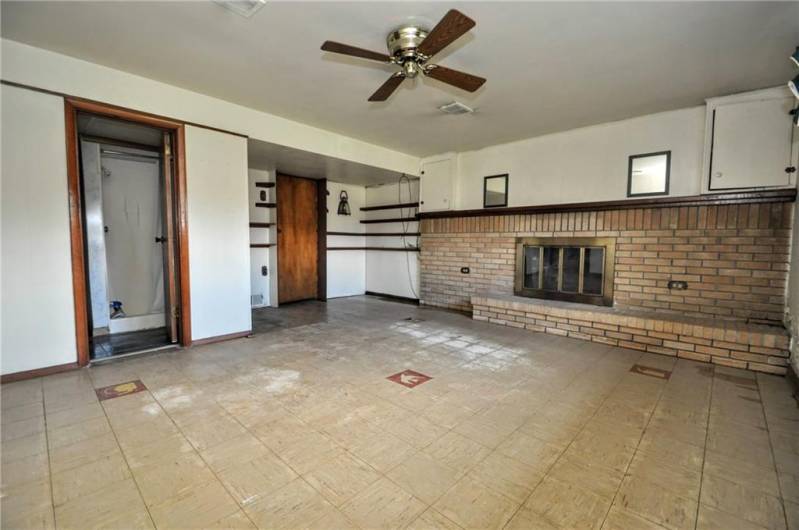 The gameroom with log burning fireplace and also access to extra storage, full bath and laundry room.