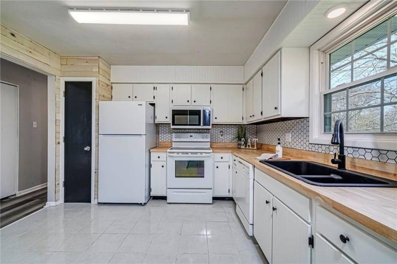 Shiplap wall, pantry, brand new fridge and microwave in the spacious kitchen.