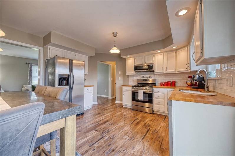 Heart of the home is this comfortable kitchen with butcher-block counters, stainless appliances, LVP flooring, and large pantry.