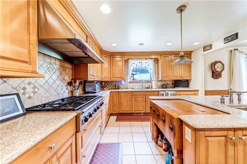 LARGE GAS STOVE TOP AND TONS OF RICH WOOD CABINETS THROUGHOUT THIS GREAT KITCHEN