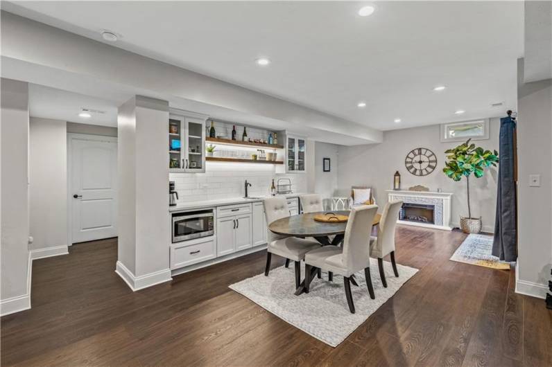 Lower level is perfect for entertaining complete with wet bar, microwave and highlighted by subway tile backsplash.