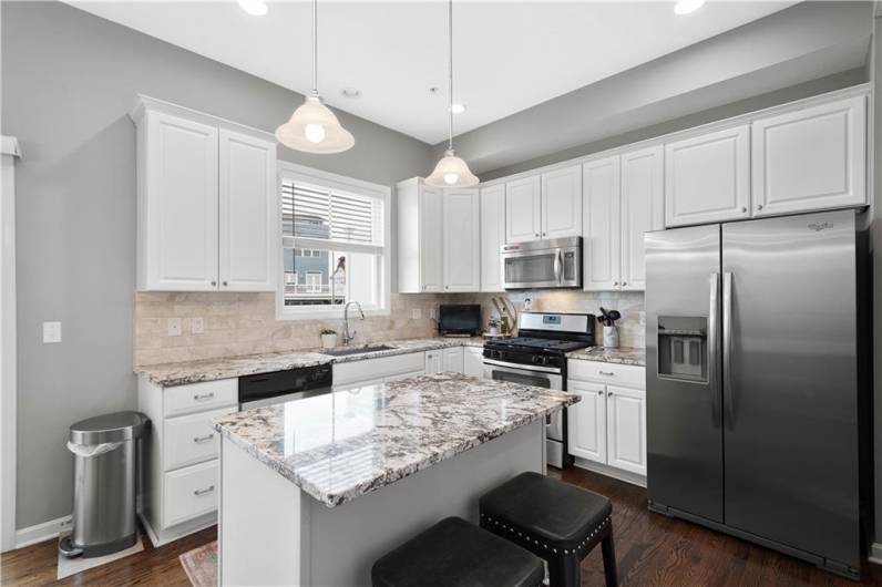 This kitchen boasts tons of natural light, stainless appliances, granite counter tops and white cabinets!