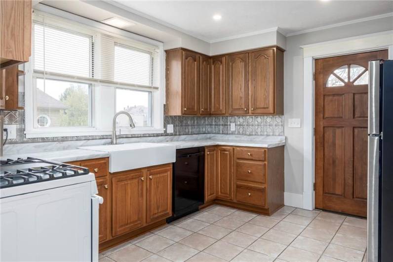 Spacious kitchen offering abundant storage in the oak cabinets, gas stove, dishwasher, and new counters.