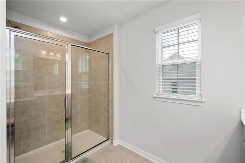 Generously spaced, you will love this tiled glass door shower.