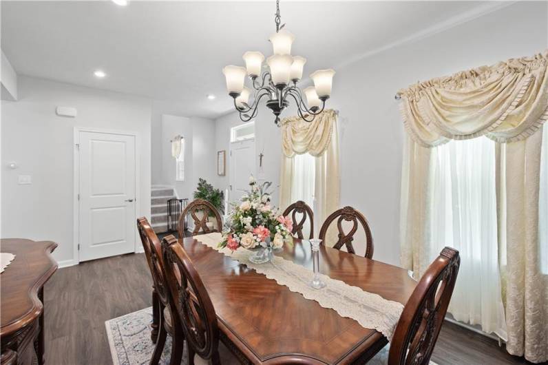 Gorgous formal dining space ready to entertain with LVP flooring and crown molding as well as a stunning chandelier.