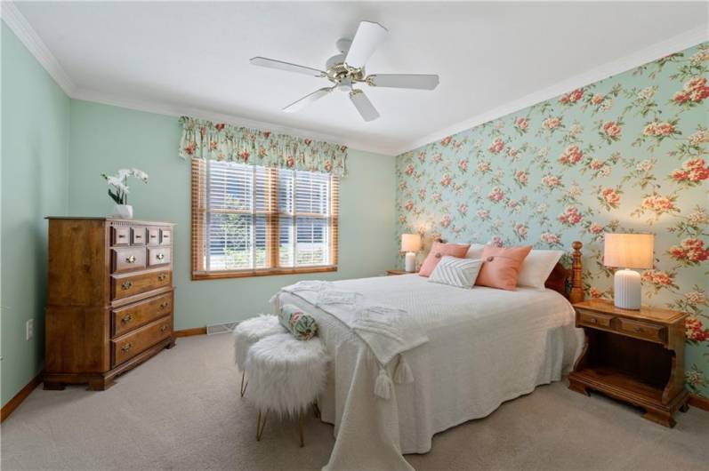 The master suite is located on the main level. It includes crown molding and a ceiling fan.