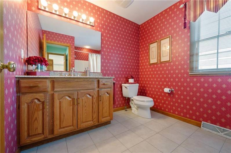 The master bath includes a large stone vanity and tile floors.