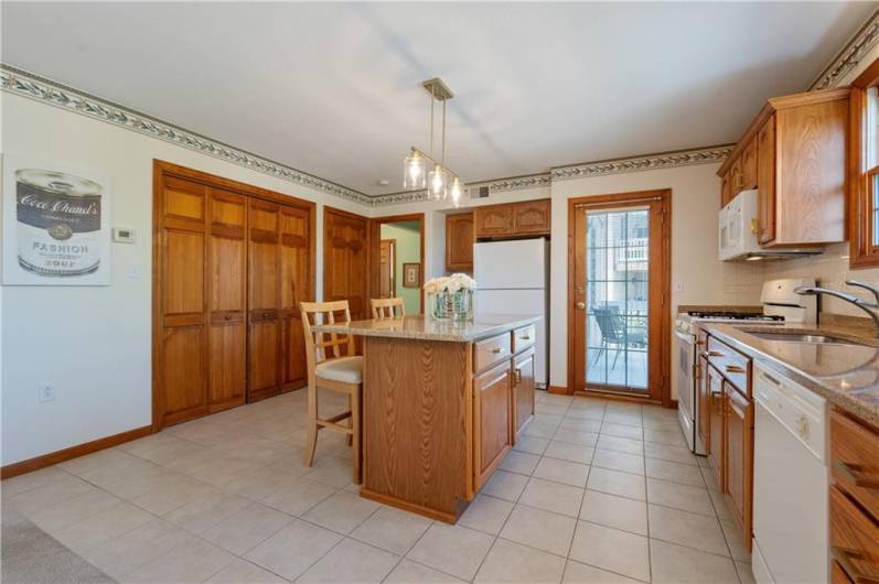 The kitchen offers beautiful quartz countertops and a tile back splash. A door leads to the deck.