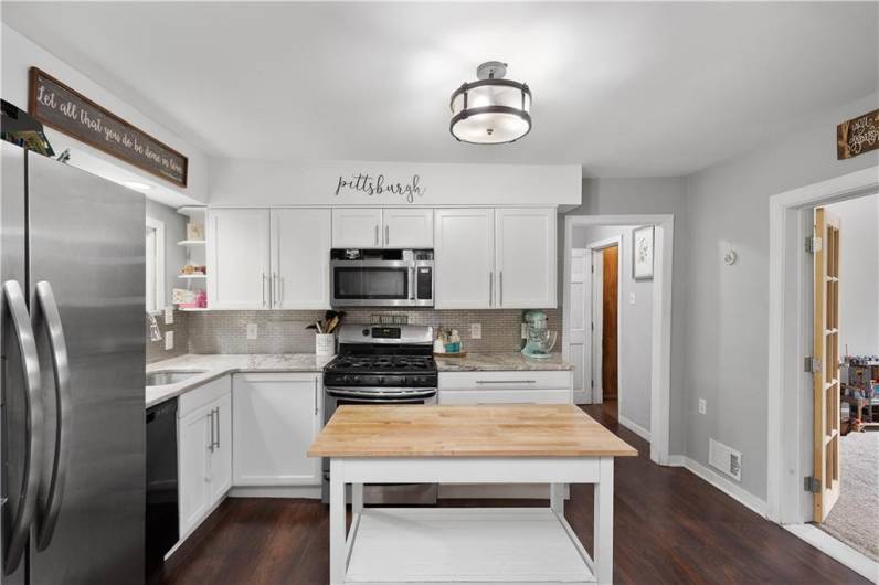 The Kitchen is open and airy! Complete with custom cabinets, granite counters, tile backsplash, island and a large pantry.