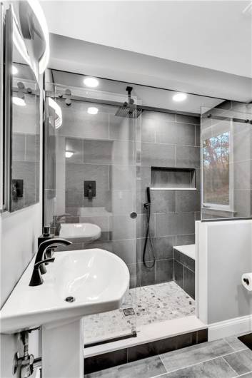Gorgeous NEW en Suite Primary Bath Features Full Tile Walk in Shower w/Rainhead Center, Heavy Duty Rolling Glass Entry, Built in Seat/Bench/Storage, and Separate Hand Shower.