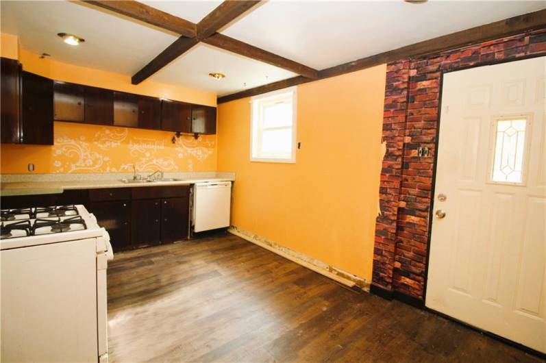 Generously sized kitchen with door to a deck in the backyard.