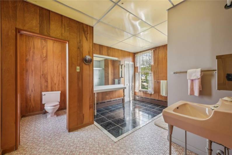 The largest bathroom belonging to the previous bedroom is just outside its door. It has its own vanity area for getting ready and a separate toilet for privacy.
