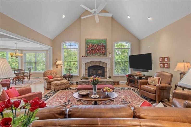 WOW! The Family Room with gleaming hardwood floors is wide open with cathedral ceilings, accent lighting with large windows and boasts a Lennox log burner with stone hearth.