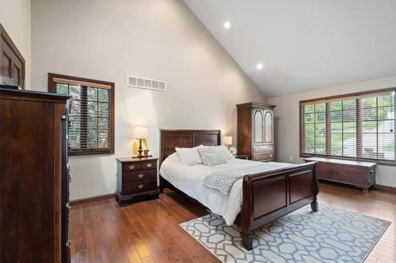 Primary bedroom with hardwood floors and vaulted ceiling!