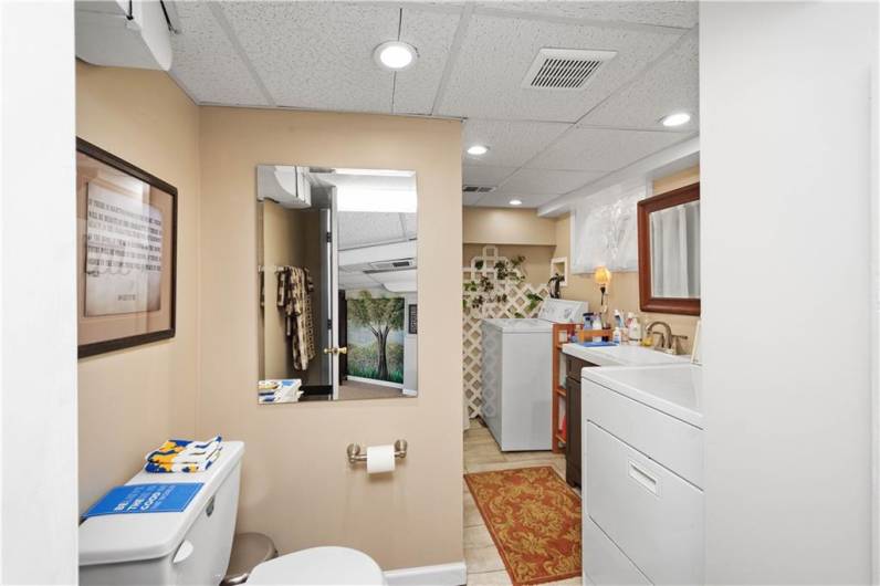 The lower level full bathroom shares the space with the washer and dryer and offers storage space as well.