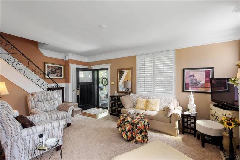 The living room with neutral carpet and paint welcomes you upon entering the home. Crown molding and plantation shudders complete the ambience. A custom designed wrought iron railing leads to the second floor bedrooms and bath.